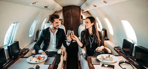 couple enjoys a meal and drinks while on private jet Helland & Hurwitz Attorneys at Law Colorado