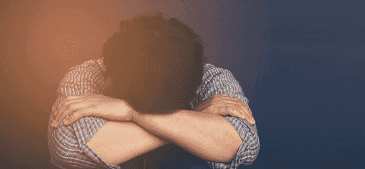 distressed person puts head in knees thinking about divorce Helland & Hurwitz Attorneys at Law Colorado