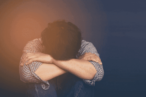 distressed person puts head in knees thinking about divorce Helland & Hurwitz Attorneys at Law Colorado