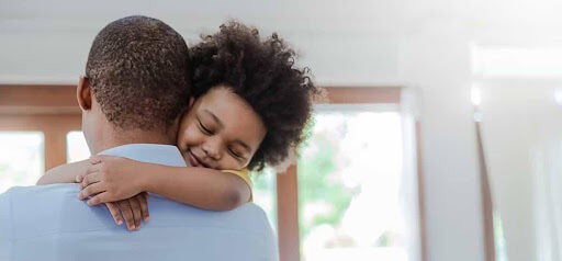 young child hugs dad around the neck Helland & Hurwitz Attorneys at Law Colorado