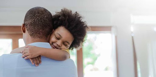 young child hugs dad around the neck Helland & Hurwitz Attorneys at Law Colorado