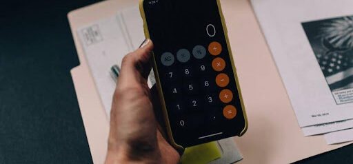 woman uses iPhone calculator to figure out her financials Helland & Hurwitz Attorneys at Law Colorado