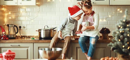 two children enjoy the holidays in the kitchen making treats Helland & Hurwitz Attorneys at Law Colorado
