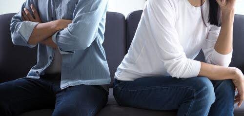 man and woman face away from each on couch not being to resolve differences Helland & Hurwitz Attorneys at Law Colorado