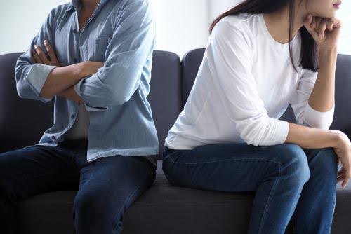 man and woman face away from each on couch not being to resolve differences Helland & Hurwitz Attorneys at Law Colorado
