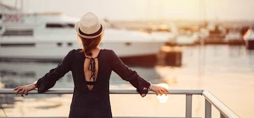 woman wearing hat looks toward harbor and a boat wondering about her high asset divorce Helland & Hurwitz Attorneys at Law Colorado