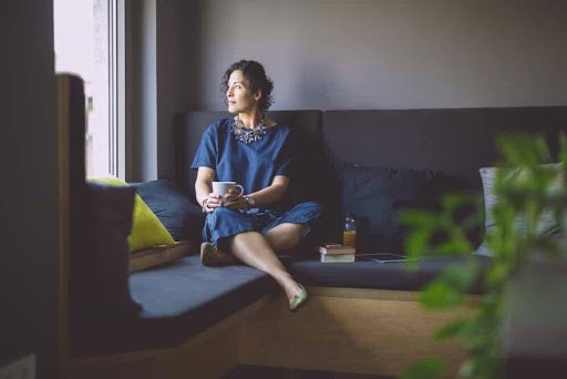 woman sits on couch thinking about her high net worth pending divorce Helland & Hurwitz Attorneys at Law Colorado