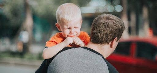 father carries upset son to a car Helland & Hurwitz Attorneys at Law Colorado