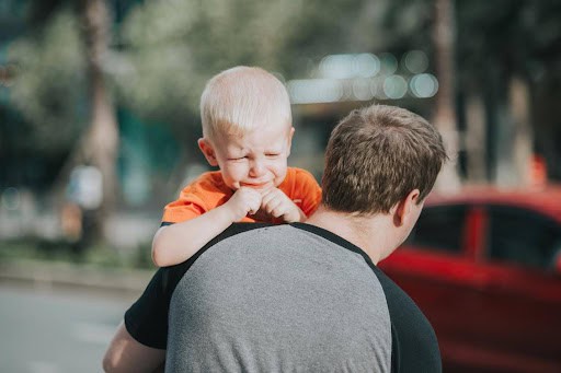 father carries upset son to a car Helland & Hurwitz Attorneys at Law Colorado