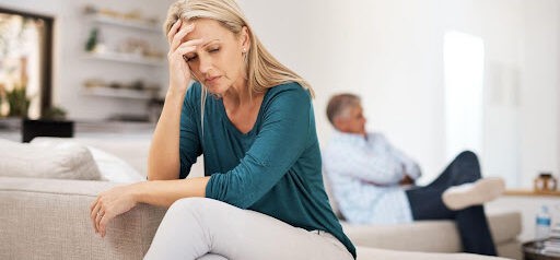 man sits on one edge of couch while woman sits on opposite side, both showing signs of stress Helland & Hurwitz Attorneys at Law Colorado