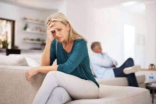 man sits on one edge of couch while woman sits on opposite side, both showing signs of stress Helland & Hurwitz Attorneys at Law Colorado