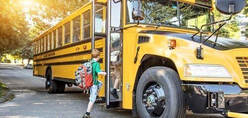 young boy in green shirt gets on school bus Helland & Hurwitz Attorneys at Law Colorado