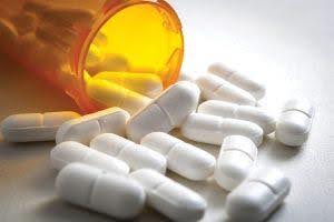 pill bottle knocked over showing possible substance abuse with white pills on table Helland & Hurwitz Attorneys at Law Colorado
