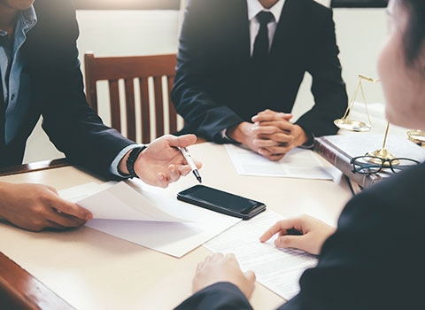 image of three attorneys discussing legal documents Helland & Hurwitz Attorneys at Law Colorado