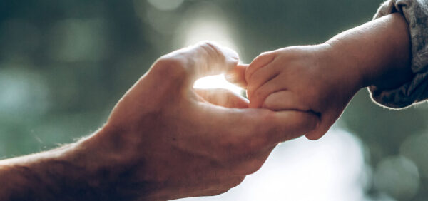 hero image close up of child hanging on to father's finger Helland & Hurwitz Attorneys at Law Colorado