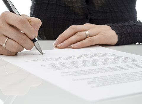 hero image of woman signing legal document Helland & Hurwitz Attorneys at Law Colorado