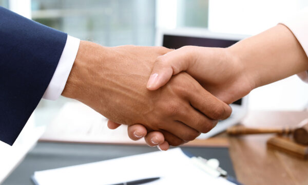 close up of man and woman shaking hands agreeing on arbitration Helland & Hurwitz Attorneys at Law Colorado