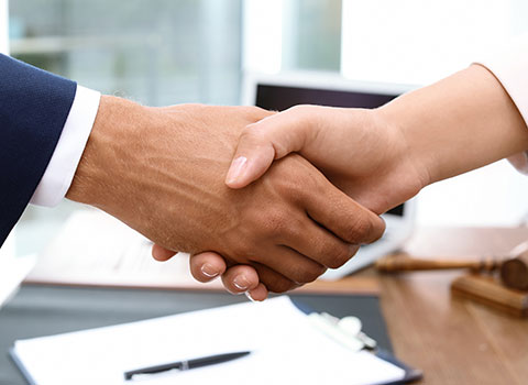 man and woman agree during arbitration and shake hands Helland & Hurwitz Attorneys at Law Colorado
