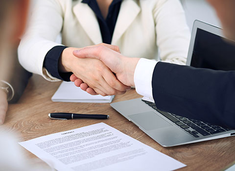 woman and man shake hands after mediation meeting Helland & Hurwitz Attorneys at Law Colorado