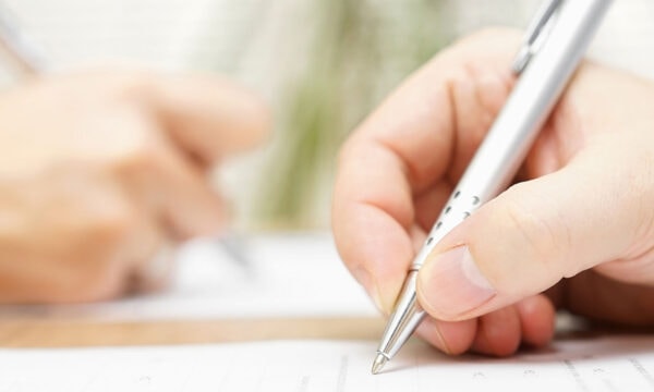 close up of man signing prenup Helland & Hurwitz Attorneys at Law Colorado